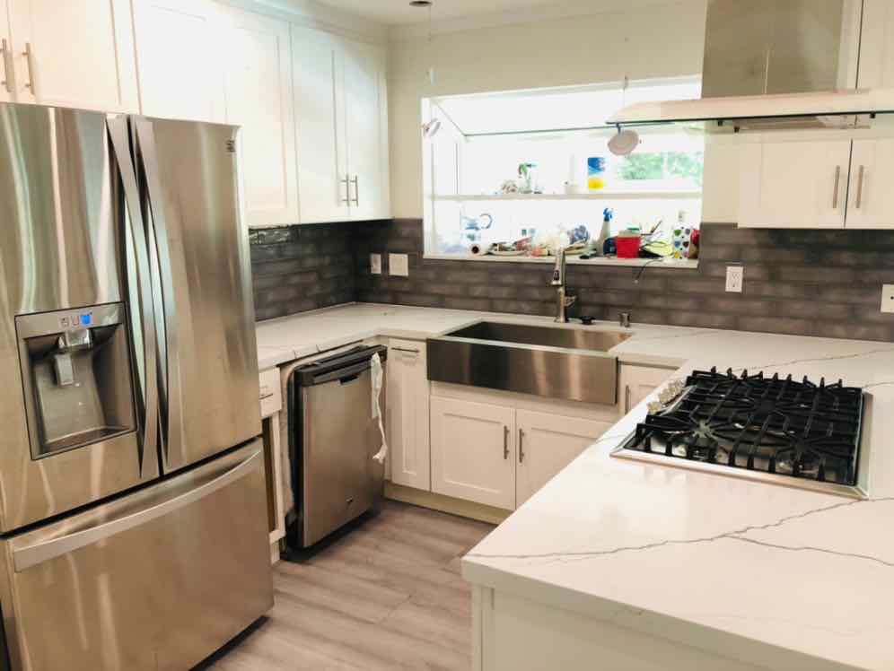 A client kitchen after cleaning, with polished counters, sink and stainless appliances
